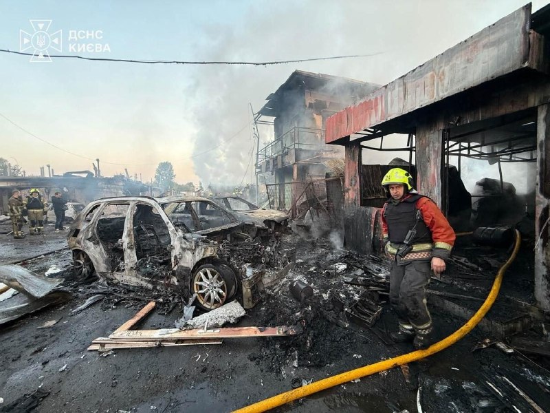 Brandweerlieden blussen een brand in een verwoest gebouw na de nachtelijke aanval