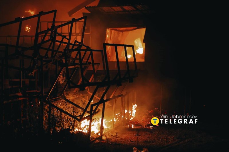 Brandweerlieden blussen een brand in een verwoest gebouw na de nachtelijke aanval