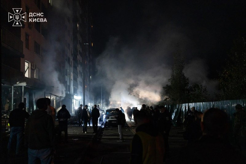 Räddningspersonal arbetar på platsen för en brand i ett bostadsområde i Kyiv på natten
