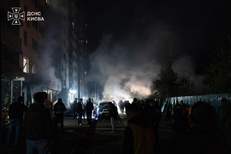 Räddningspersonal arbetar på platsen för en brand i ett bostadsområde i Kyiv på natten