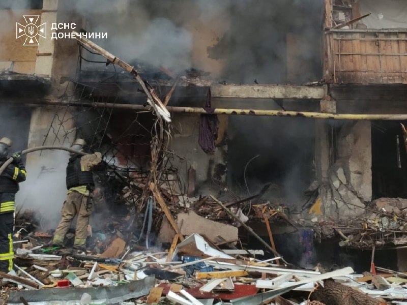 Рятувальники працюють на місці пожежі в житловому районі, видно пошкоджений пожежний автомобіль