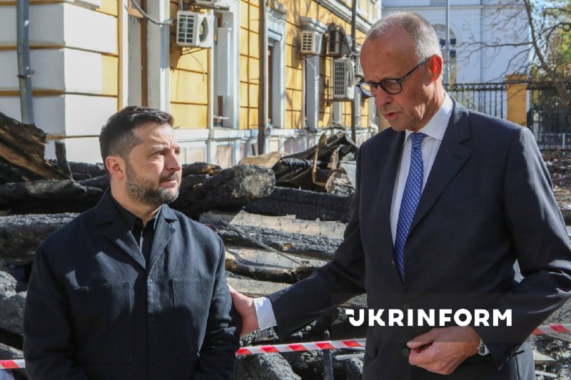 O presidente da Ucrânia e o chanceler da Alemanha observam o edifício destruído da academia de ciências em Kiev