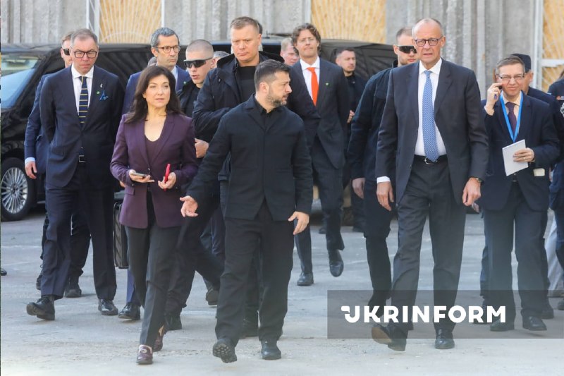 O presidente da Ucrânia e o chanceler da Alemanha observam o edifício destruído da academia de ciências em Kiev