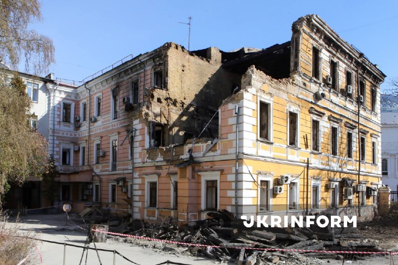 O presidente da Ucrânia e o chanceler da Alemanha observam o edifício destruído da academia de ciências em Kiev