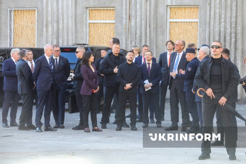 O presidente da Ucrânia e o chanceler da Alemanha observam o edifício destruído da academia de ciências em Kiev