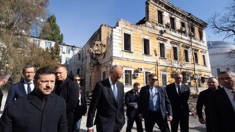 O presidente da Ucrânia e o chanceler da Alemanha observam o edifício destruído da academia de ciências em Kiev